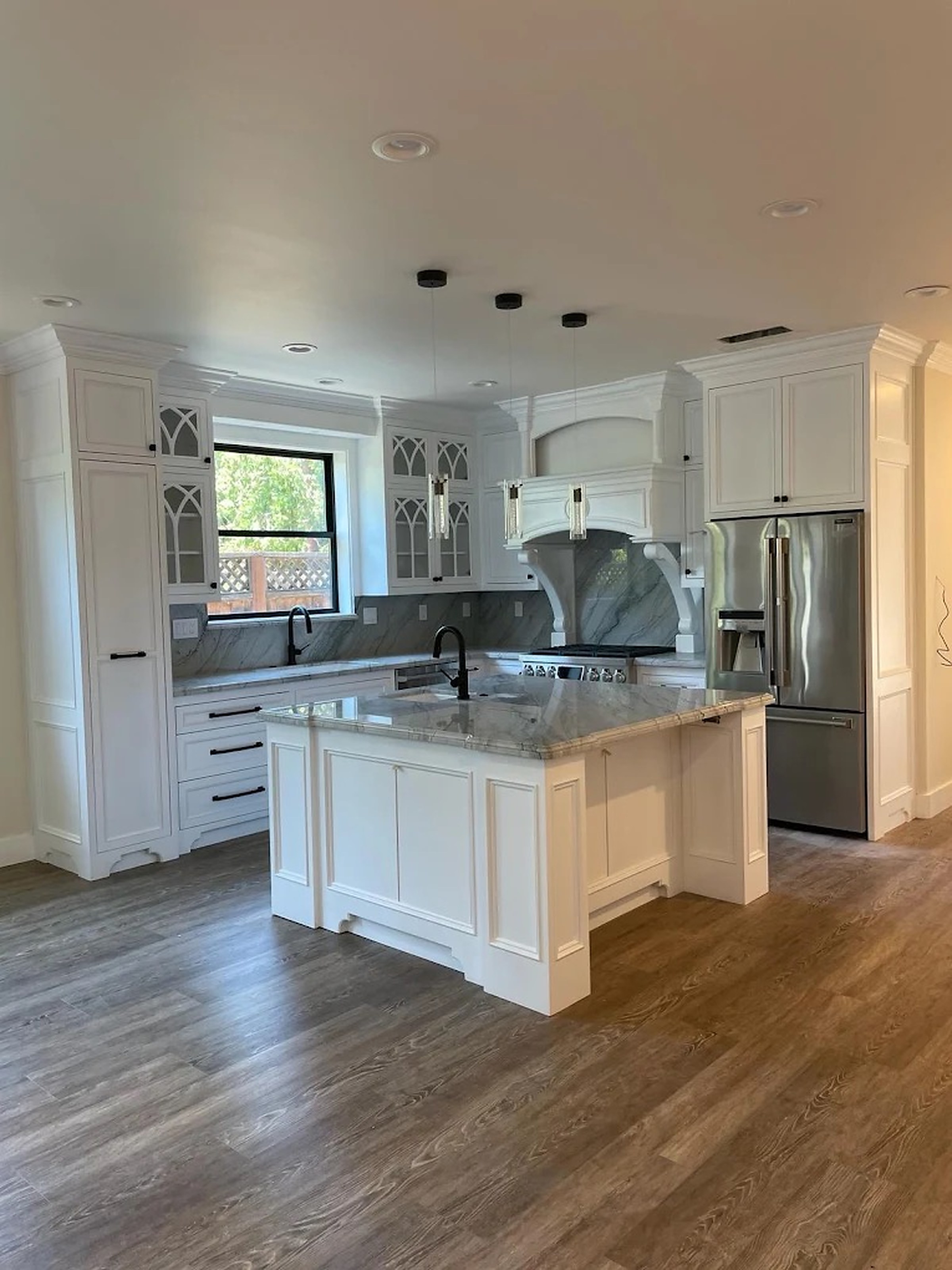 Arched glass display cabinets and slab marble island